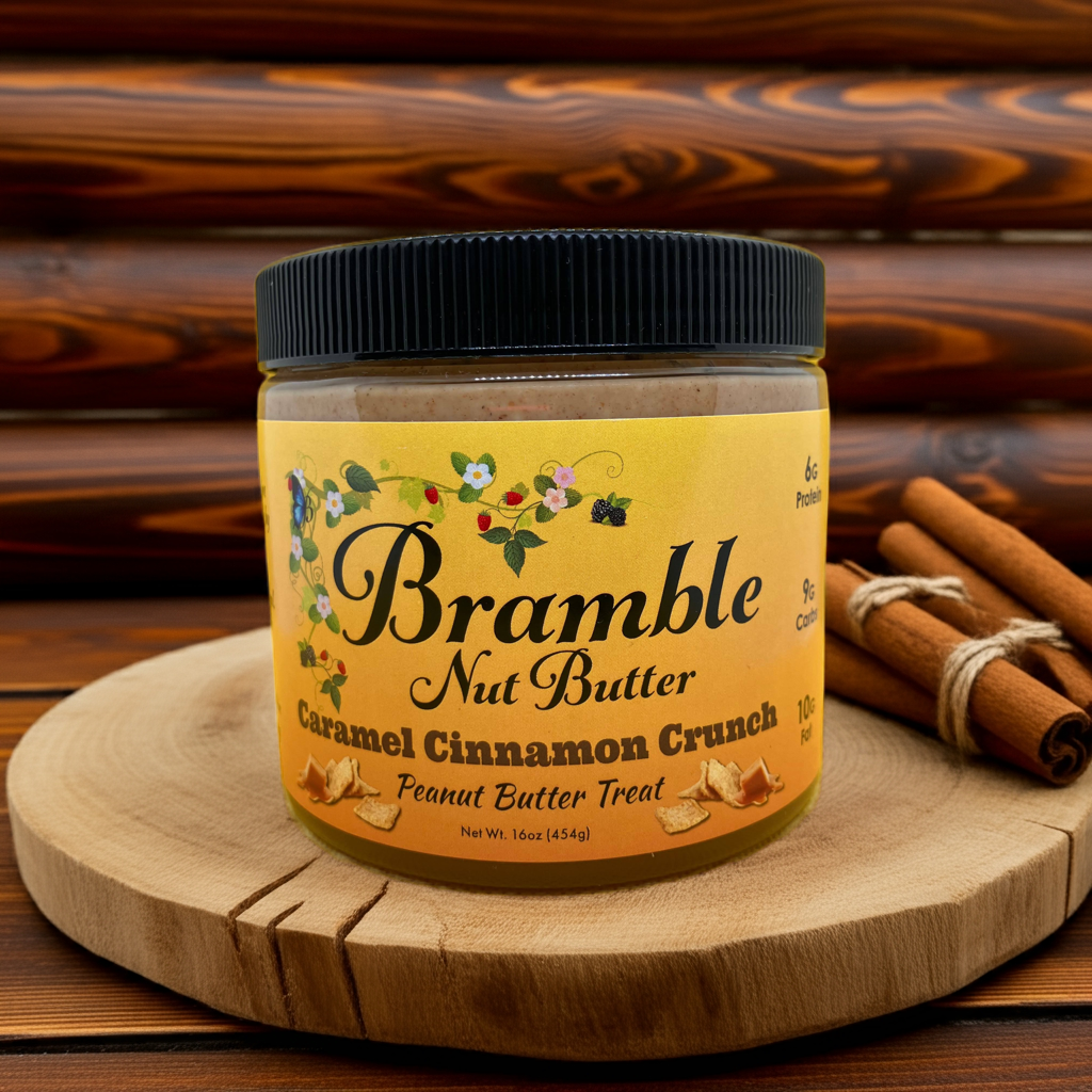 Jar of Bramble Nut Butter Caramel Cinnamon Crunch on a wooden surface with cinnamon sticks.