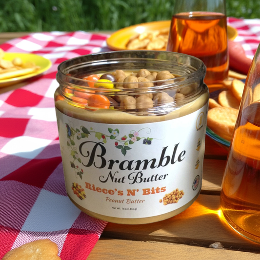 Jar of Bramble Nut Butter on a picnic table with snacks and drinks.